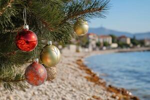 Close up of Festive Baubles on a Beach side Pine Tree with Crystal Clear Ocean in the Background photo
