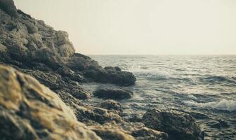 A rocky shoreline with a calm ocean in the background photo