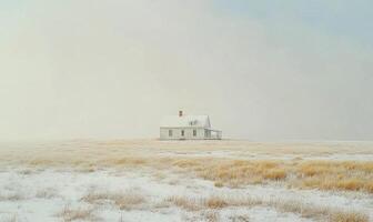 A small white house sits in a field of snow photo