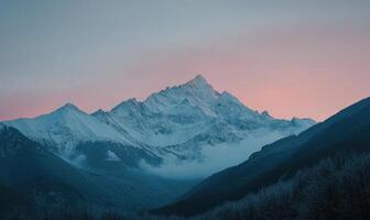 A mountain range with a mountain in the background and a pink sky photo