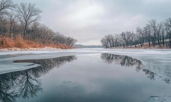 A lake with a snowy bank and trees in the background photo