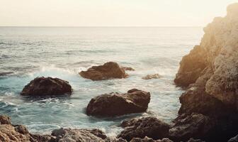 The ocean is calm and the rocks are scattered along the shore photo
