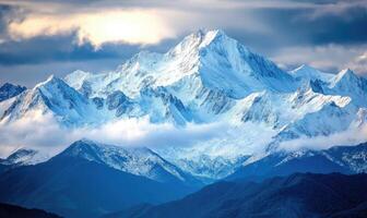 The mountains are covered in snow and the sky is cloudy photo