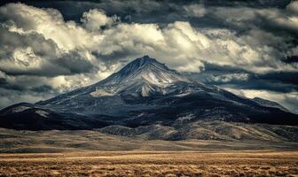 A mountain with a cloudy sky in the background photo