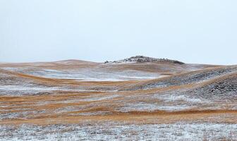 A snowy field with a hill in the background photo