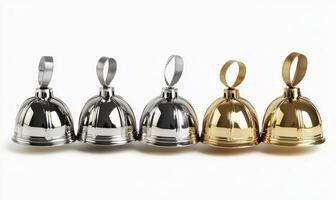 A row of five gold and silver bells are lined up on a white background photo