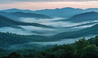 The mountains are covered in fog and the sky is a beautiful shade of blue photo