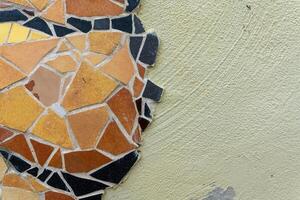 A close-up of a colorful mosaic on a light green wall, showcasing the intricate patterns and textures photo