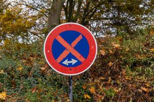 red and blue sign with an X on it is on a hillside photo