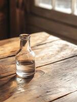 A glass bottle on a wooden table photo