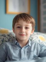 A boy sitting on a bed smiling photo