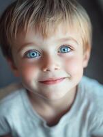 A young boy with blue eyes looking up at the camera photo