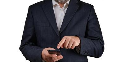 A businessman wearing an elegant suit is using a smartphone. He is looking at the screen with a smile, indicating satisfaction while engaging with clients or managing his work-related tasks. photo