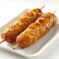 two skewers of food on a white plate photo