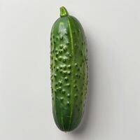 A whole cucumber with prickly skin on a grey background. photo