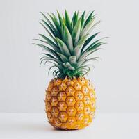 A whole, ripe pineapple with a green top and yellow bottom. photo