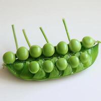 displays a pea pod that has been cut open and arranged to hold several green peas. photo