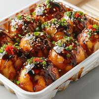 A dish of chicken karaage coated in a rich, sweet and savory sauce. Served with sesame seeds, photo