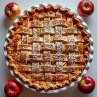 A whole apple pie with a golden crust and a lattice top filled with fresh apples. photo