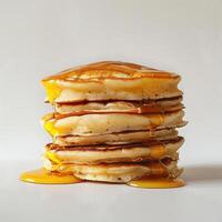 A stack of pancakes topped with syrup on a countertop. photo