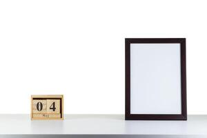 Wooden calendar 04 may with frame for photo on white table and background