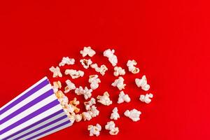 box with popcorn striped in different colors on a red background photo