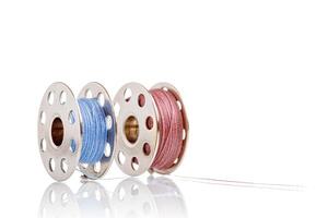 spools of blue and pink thread on a white background photo
