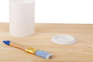 white paint with a brush on a wooden background with texture photo