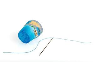 thimble and needle and thread on a white background photo
