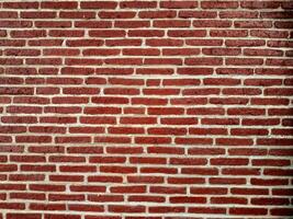 A textured red brick wall with a classic horizontal pattern, showcasing the rustic charm and architectural simplicity of traditional masonry work. photo