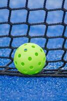 isolated pickleball ball near net with blurred background photo