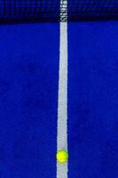 Overhead photo of the line of a blue synthetic paddle tennis court.