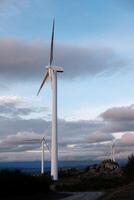 windmills in a wind farm at sunset with a cloudy sky in the background, concept renewable energy photo