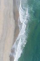 Aerial view of sandy beach and ocean with waves photo