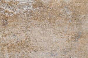 A wall with a rough texture and a few holes. The wall is brown and has a somewhat worn appearance photo