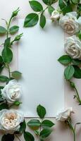 White Roses and Green Leaves Surrounding a Blank Card photo