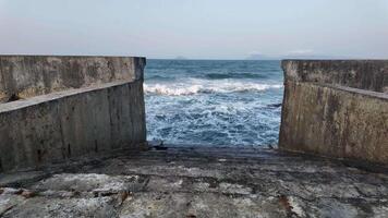 Rugged stone seawall leading to crashing ocean waves, evoking concepts of tranquility and maritime adventure video