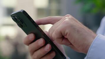 Close up Caucasian male hands arms holding mobile phone scrolling screen social media app unrecognizable man unknown businessman guy business chat smartphone using online internet shopping in city video