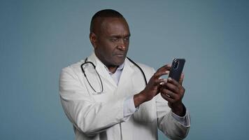 African American man doctor physician using medical virtual mobile application on phone remote browsing analysis results chat with patient on smartphone distance consultation medicine and modern tech video