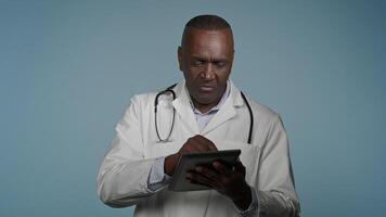 African American man professional doctor therapist consultant consulting patient using digital tablet for online appointment modern treatment read data analysis results use virtual medical application video