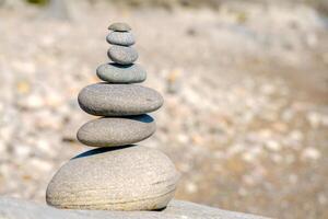 Pyramid of stones. Unstable balance of stone objects. Idyllic state of nature. photo
