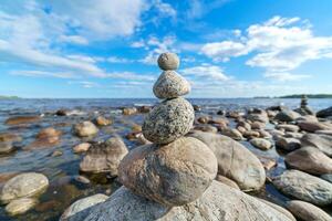 Pyramid of stones. Unstable balance of stone objects. Idyllic state of nature. photo
