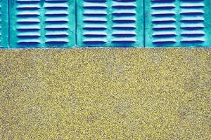 Old azure emerald grille ventilation holes lattice, wall with stone chips photo