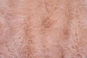 Soft texture of a faux fur coat in warm peach fuzz tones photo