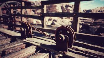 Rustic wooden pulley system on a weathered bridge in a serene landscape video