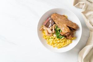 Egg noodles served dry with braised duck photo