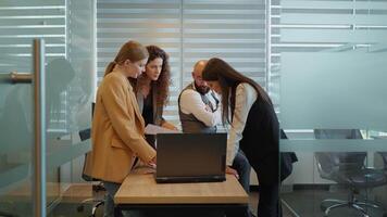 Three women and man working together planning success strategy video
