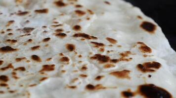 A CloseUp View of Deliciously Crispy and Flavorful Flatbread on a Black Surface Background video