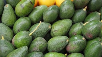 customer choosing avocado display for sale at local store video