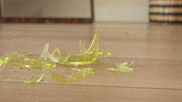 Shattered and Broken Green Glass Fragments Are Scattered All Over a Wooden Floor Surface video